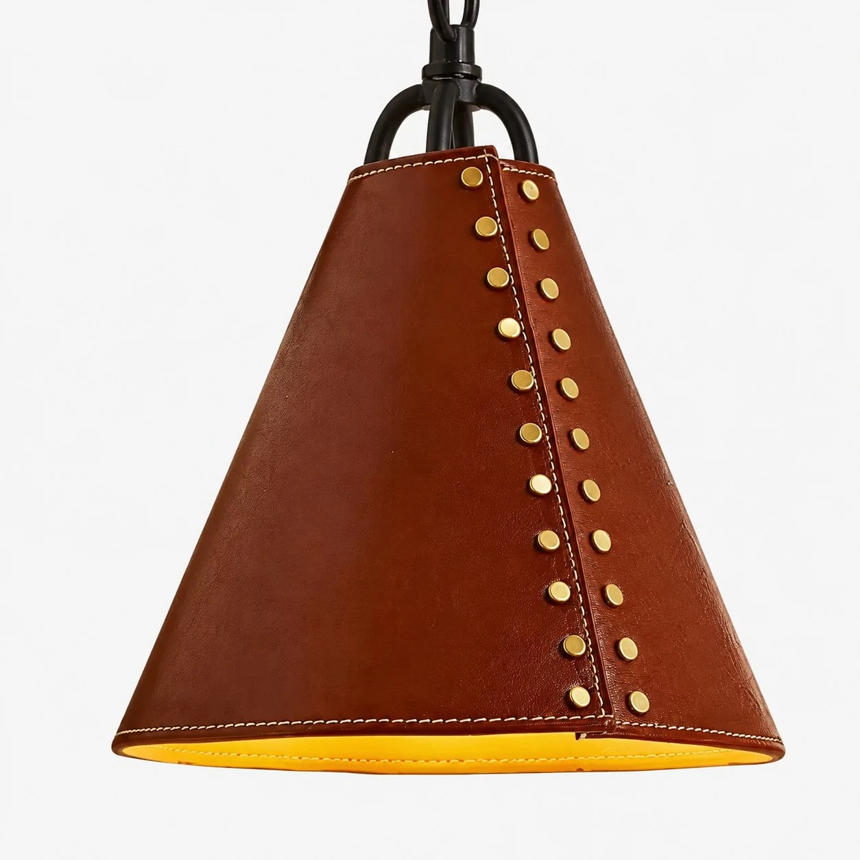 Close view of red leather cone shade with gold rivets and stitched lower edge